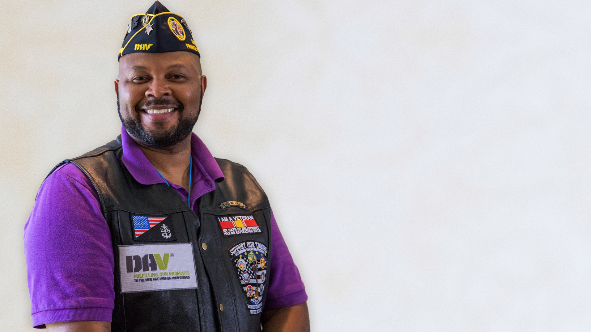 Smiling Veteran wearing Disabled American Veteran vest and hat